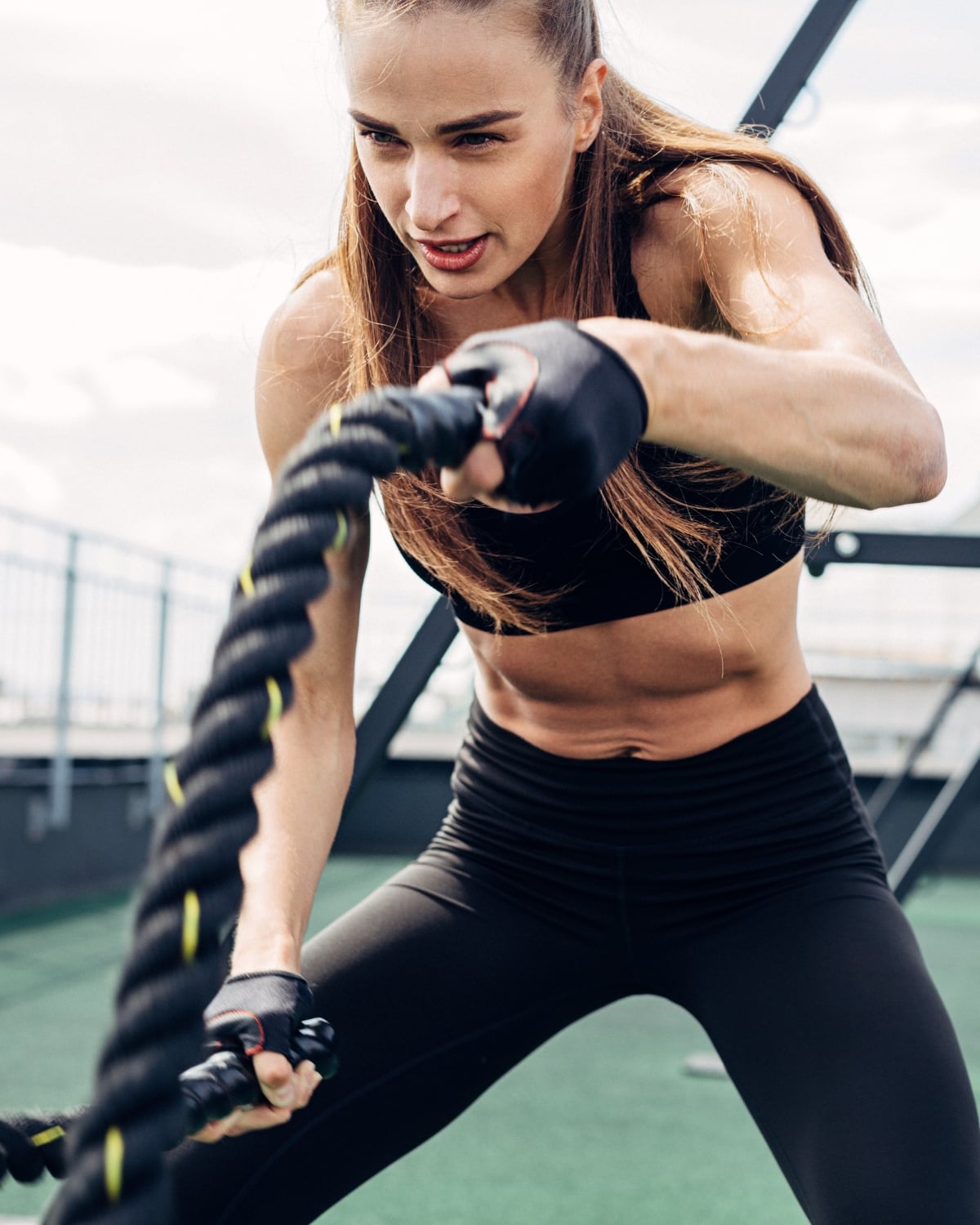 Athlete training with battle ropes representing sports massage recovery at The Knotstop in San Diego